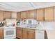 Well-lit kitchen with wood cabinets, white appliances, and a functional layout at 10315 Cortez W Rd # 24H, Bradenton, FL 34210
