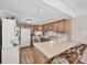 Cozy kitchen with wooden cabinets, standard appliances, and a breakfast bar at 10315 Cortez W Rd # 24H, Bradenton, FL 34210