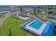 Aerial view showcasing the community pool, tennis courts, and surrounding homes, highlighting recreational amenities at 10315 Cortez W Rd # 24H, Bradenton, FL 34210