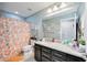 A stylish bathroom featuring a granite vanity top, dark cabinets, and decorative shower curtain at 11092 58Th Street Cir E, Parrish, FL 34219