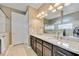 A full bathroom with double sinks, granite counters, and dark cabinets at 11092 58Th Street Cir E, Parrish, FL 34219
