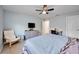 A comfortably furnished bedroom features a ceiling fan, chair, TV, and a cozy blue quilt at 11092 58Th Street Cir E, Parrish, FL 34219