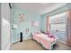 A cozy pink and blue bedroom features a plush bed, whimsical decor, and natural light at 11092 58Th Street Cir E, Parrish, FL 34219