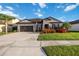 Beautiful one-story home featuring a well-manicured lawn, landscaping, a palm tree, and a two-car garage at 11092 58Th Street Cir E, Parrish, FL 34219