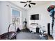 A simple gym offers a variety of exercise equipment, a TV, and light from a window at 11092 58Th Street Cir E, Parrish, FL 34219