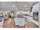 Open kitchen with white cabinets, stainless steel appliances, a large island, and seamless access to the living space at 11092 58Th Street Cir E, Parrish, FL 34219