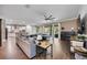 Open-concept living space featuring a large sofa, hardwood floors, and backyard access at 11092 58Th Street Cir E, Parrish, FL 34219