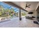 Covered patio with travertine tile, ceiling fan, television, and ample room for relaxing at 11092 58Th Street Cir E, Parrish, FL 34219