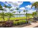 Scenic backyard view features lush green lawn, mature palm trees, and waterfront access, perfect for outdoor enjoyment at 12224 Garden Lake Cir, Odessa, FL 33556