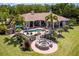 Aerial view showcasing a backyard with a pool, patio seating, and a fire pit, perfect for outdoor entertaining at 12224 Garden Lake Cir, Odessa, FL 33556