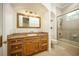 A well-lit bathroom featuring a vanity, toilet, and shower-tub combo with glass doors at 12224 Garden Lake Cir, Odessa, FL 33556