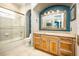 Well-lit bathroom featuring a vanity, toilet, and shower-tub combo with tiled walls at 12224 Garden Lake Cir, Odessa, FL 33556