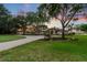 Grand estate home with manicured lawn and brick circular driveway, set against a colorful sunset sky at 12224 Garden Lake Cir, Odessa, FL 33556