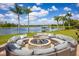 Inviting outdoor fire pit area with comfortable seating, perfect for cozy evenings by the lake at 12224 Garden Lake Cir, Odessa, FL 33556