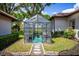 Backyard greenhouse featuring stepping stone access and a variety of plants inside at 12224 Garden Lake Cir, Odessa, FL 33556