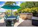Outdoor dining area with spa and a large umbrella, ideal for al fresco dining and enjoying the water view at 12224 Garden Lake Cir, Odessa, FL 33556