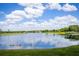 Beautiful lake view with lush green trees lining the shore on a sunny day with bright blue sky at 12224 Garden Lake Cir, Odessa, FL 33556