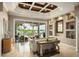 Bright living room featuring coffered ceilings, lake views, a bar, and stylish decor at 12224 Garden Lake Cir, Odessa, FL 33556