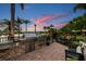 Outdoor grill area with bar seating, a lakeside view, and a landscaped garden for elegant outdoor dining at 12224 Garden Lake Cir, Odessa, FL 33556