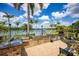 A premium outdoor kitchen with a stone bar, a grill, and lakeside views offering luxury outdoor living at 12224 Garden Lake Cir, Odessa, FL 33556