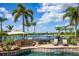 Beautiful pool area with outdoor kitchen, grill, and relaxing lounge chairs overlooking the lake on a sunny day at 12224 Garden Lake Cir, Odessa, FL 33556