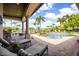 Stunning outdoor pool area with covered patio, lounge chairs, and lush landscaping, creating a relaxing oasis at 12224 Garden Lake Cir, Odessa, FL 33556