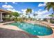Beautiful pool featuring an outdoor kitchen, chaise lounges, and meticulous landscaping at 12224 Garden Lake Cir, Odessa, FL 33556