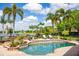 Inviting swimming pool and outdoor area with a lake view, palms, and lush landscaping at 12224 Garden Lake Cir, Odessa, FL 33556
