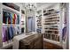Organized walk-in closet with clothing racks, shoe shelves, dresser island, and hardwood floors at 12224 Garden Lake Cir, Odessa, FL 33556
