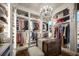 Luxurious walk-in closet with custom shelving, chandelier, and a dresser-style island at 12224 Garden Lake Cir, Odessa, FL 33556