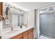 Bright bathroom featuring double sinks with a wood vanity and a large shower with glass door at 1235 Dockside Place # 108, Sarasota, FL 34242