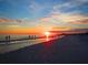 Sunset on the beach with people walking along shoreline, creating a serene and picturesque scene at 1235 Dockside Place # 108, Sarasota, FL 34242