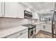Bright kitchen boasts stainless steel appliances, white cabinetry, and gorgeous marble countertops at 1235 Dockside Place # 108, Sarasota, FL 34242