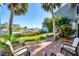 Charming patio with brick pavers, tropical landscaping, and partial waterfront views provides a cozy outdoor space at 1235 Dockside Place # 108, Sarasota, FL 34242