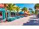 A colorful street view featuring outdoor seating at cafes and shops with palm trees lining the walkway at 1235 Dockside Place # 108, Sarasota, FL 34242