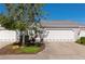 Charming home featuring a well-maintained two-car garage, lush landscaping, and inviting curb appeal at 1264 Spoonbill Landings Cir, Bradenton, FL 34209