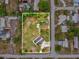 Aerial view shows the property with mature trees, a carport, and a large grassy area at 13241 Miami St, Hudson, FL 34667