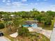 A charming light blue single story home is featured in an aerial shot surrounded by trees and greenery at 13241 Miami St, Hudson, FL 34667