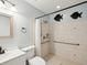 Well-lit bathroom featuring a walk-in shower with grab bars, decorative wall art and modern fixtures at 13241 Miami St, Hudson, FL 34667