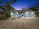 Charming single-story home featuring a flat roof, blue exterior and a spacious driveway at 13241 Miami St, Hudson, FL 34667