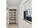 Hallway featuring a pantry with shelving and a view of the kitchen with blue cabinets at 13241 Miami St, Hudson, FL 34667