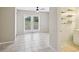 Neutral toned living room with tile flooring, a ceiling fan, and sliding glass doors to backyard at 13241 Miami St, Hudson, FL 34667