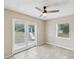 Living room with tile flooring, ceiling fan, and glass doors leading to an outdoor area at 13241 Miami St, Hudson, FL 34667