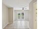 Neutral toned living room with tile flooring, a ceiling fan, and sliding glass doors to backyard at 13241 Miami St, Hudson, FL 34667