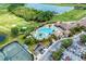 Aerial view of community center and pool area, with tennis courts, golf course, lake, and parking at 135 Sweet Tree St, Bradenton, FL 34212