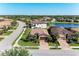 Aerial view of home nestled within a community, featuring lush landscaping and a serene pond nearby at 135 Sweet Tree St, Bradenton, FL 34212