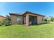 Well-maintained backyard featuring lush green grass, a covered patio, and manicured landscaping at 135 Sweet Tree St, Bradenton, FL 34212