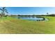 Lush backyard with a serene pond view, offering a peaceful outdoor setting surrounded by well-maintained landscaping at 135 Sweet Tree St, Bradenton, FL 34212