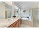 Luxurious bathroom with double sinks, soaking tub, and frameless glass shower at 135 Sweet Tree St, Bradenton, FL 34212