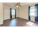 A well-lit bedroom featuring dark wood flooring, complemented by blue drapes and a ceiling fan at 135 Sweet Tree St, Bradenton, FL 34212
